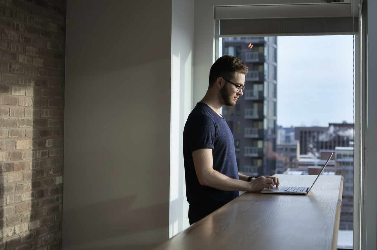 Person at standing desk working on laptop